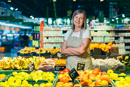 一名超市工人的高级灰发妇女肖像画 劳动者传播水果微笑杂货店务员零售生意围裙店铺成人老年女性图片