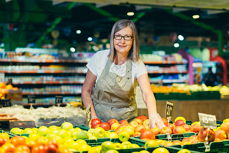 在超市杂货店雇员处戴眼镜的高级妇女肖像相机食物市场价格店铺女性老年人士老板雇主图片