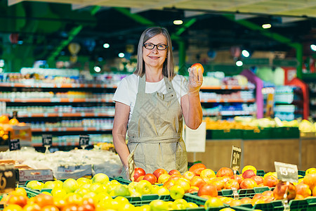 在超市杂货店雇员处戴眼镜的高级妇女肖像职员人士职业经理女性杂货商价格购物商业员工图片