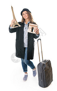 带着旅行包的年轻女孩拿着法国的象征 凯旋门的模型和白色背景中的凯旋门图片