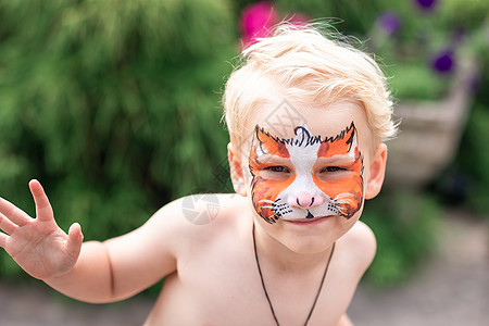 可爱的小男孩 用他的脸上涂漆蓝色生日孩子老虎面具化妆品童年绘画幼儿园假期图片