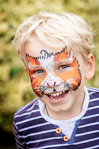可爱可爱的小男孩 用他的脸涂漆童年派对化妆品艺术老虎动物乐趣绘画孩子男生图片