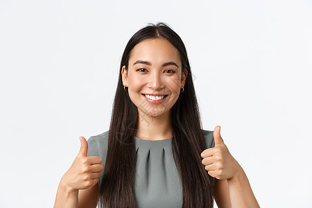 满意而快乐的微笑亚洲女商务人士的特写 他们给予积极的反馈 称赞干得好 表现出色 工作姿态出色 竖起大拇指高兴地站着白色背景女性人背景图片