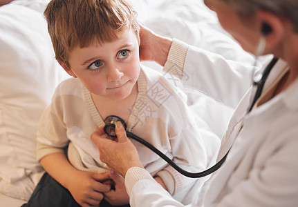 医生检查一个小男孩 在家中用听诊器在床上看病 他正在医院里做手术图片