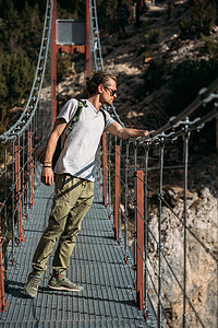 站在吊桥上 仰望湖边的登山者 旅行概念图片
