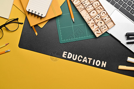 黄色背景的顶级文具和电脑笔记本电脑 回到学校的概念图片