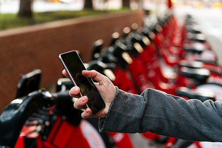 一辆出租自行车停靠旁边的手持电话互联网车辆服务屏幕民众运输代码创新女士社会图片
