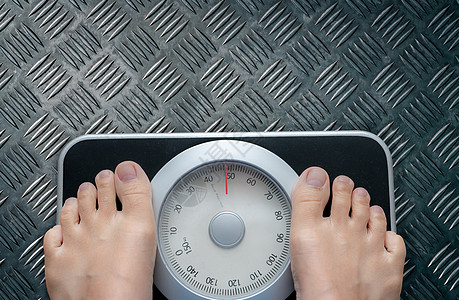 体重秤上脚的顶视图 女性在控制饮食后在体重秤上称重 健康的体重 体重和脂肪减少的概念 称重机 身体质量指数或 BMI 概念图片