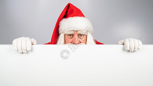圣诞老人在白背景广告后面偷看 圣诞快乐 圣诞快乐祖父广告牌喜悦手套庆典男性木板销售问候语假期图片
