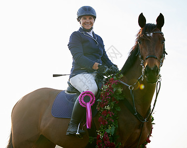 胜利是我们的了 一个有魅力的年轻女骑师坐在她的马背上 在赢家圈里图片