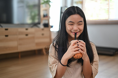 快乐的年青女人喜欢喝珍珠泡泡奶茶图片