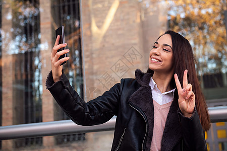 年轻女人用电话拍自拍图片