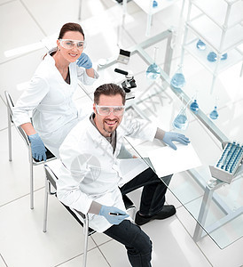 顶部视图 科学家在实验室的桌子上技术员研究研究员生物化学玻璃职业男性团队测试图片