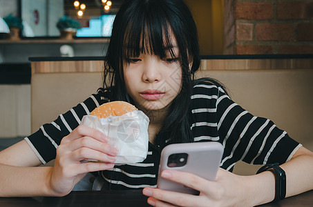 拥有移动智能手机社交网络互联网技术并吃汉堡包快餐的女人们 (请查看InfoFinland上的图片
