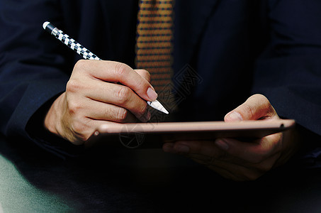 商务人士在办公桌上申请时签署数字在线平板电脑合同网络套装签名工作笔记基准管理人员桌子人士男人图片