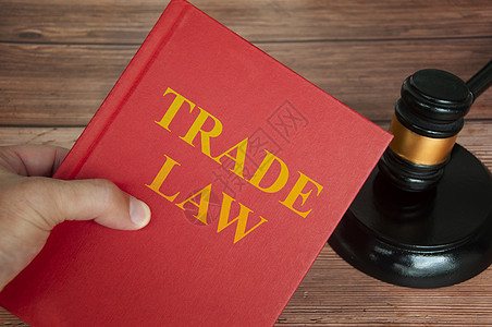 贸易法关于法律书籍的文本 法官大锤以木制案桌背景图片