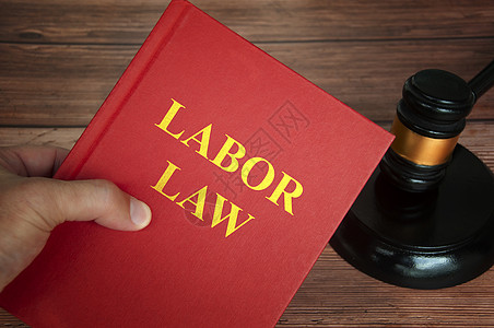 法律书籍中的劳动法文本 法官用木制桌子背景的壁炉图片