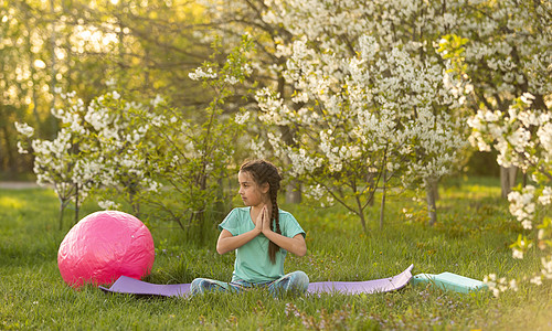 一个小女孩做瑜伽 躺在公园体育垫子上 健康的生活方式是一种幼稚习惯 笑声花园孩子后院喜悦童年后代女孩夫妻活力生活图片