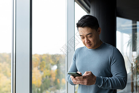 亚洲商务人士在办公室使用电话 一个男人看着电话屏幕的画像图片