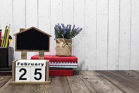 2月25日日历日期的文字 木制板和木制桌子上的文具图片