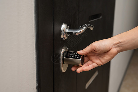女人打开公寓门的密码锁 无钥匙入门了  没有钥匙进门房子女手代码按钮控制技术犯罪检测酒店入口图片