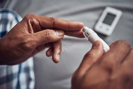 让我们不要粉饰它 糖尿病可能很危险 一个面目全非的男人在家里的床上用手指进行血糖测试图片