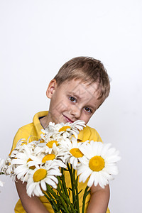 一个可爱的男孩 带着一束美丽的大雏菊 一个孩子的肖像 有趣而可爱的面部表情 选择性的焦点礼物生活晴天乐趣家庭日阳光快乐微笑草地花图片