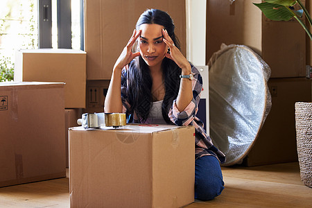 搬家是新开始的另一种方式 一个年轻女人收拾行李准备搬家图片