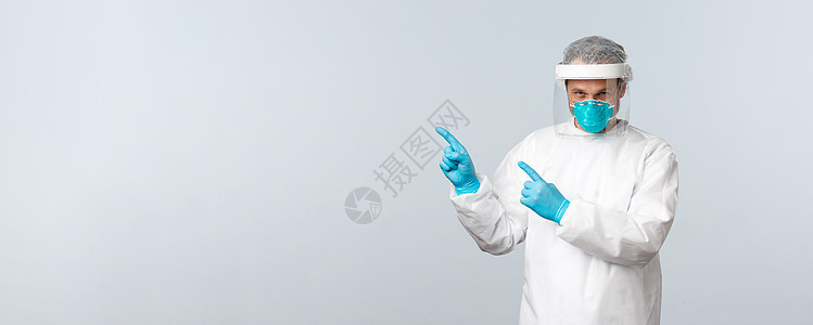 Covid19 预防病毒 医护人员和疫苗接种概念 穿着个人防护装备的严肃医生用手指指着左上角的信息横幅病人感染医师保险医院外科肺图片