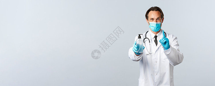 Covid19 预防病毒 保健工作者和接种疫苗概念 微笑医生解释使用手消毒剂的重要性 展示规则一 戴医疗面具和手套医院保险科学管图片