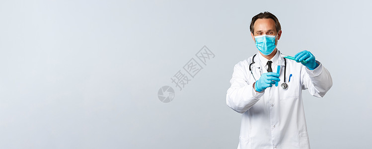Covid19 预防病毒 医护人员和疫苗接种概念 戴着医用口罩和手套的微笑医生将化学成分倒入另一个试管中 进行疫苗测试科学管子实图片