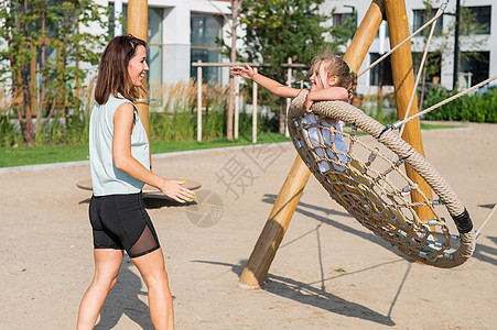 白种女人和小女孩在游乐场玩得开心点 她喜欢看球赛城市跷跷板母亲闲暇活动女孩女士娱乐婴儿孩子图片