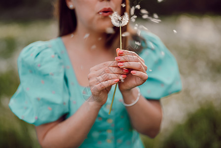 快乐的女人美丽吹在公园里的蒲公英上 复古蓝色连衣裙的女孩 希望 快乐的概念 春天 审美肖像自由太阳头发女性阳光闲暇日落幸福种子嘴图片