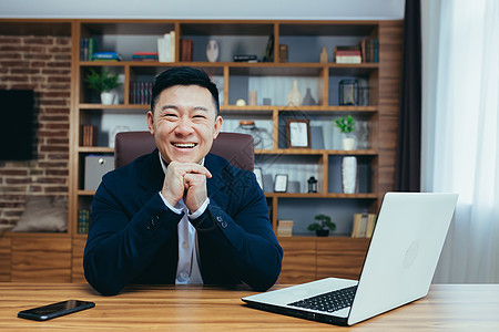 一位成功的亚洲商务人士的肖像 在办公室工作的人坐在桌子上 A导演职业人士标志技术施工员工银行职场营销图片