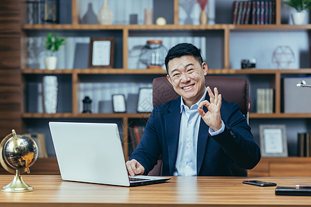 一个成功的亚洲商务人士的肖像 在一个经典办公室里 老板看着摄影机看相片图片