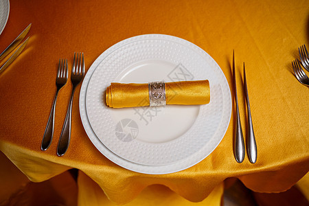配有叉 刀和金餐巾的优美桌餐具丝带金子桌子装饰品银器美食宴会接待奢华图片