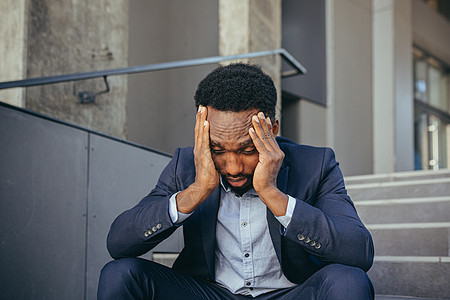 因工作成果而沮丧的非洲商务人士在楼梯上坐着沮丧的落败者人士套装失败哭泣危机疼痛办公室经理男性损失图片