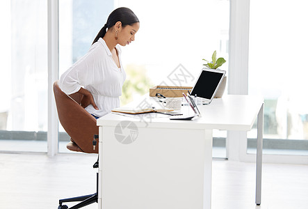 一位年轻的女商务人士坐在一个办公桌旁 在现代办公室里看着疲惫不堪 (笑声)图片