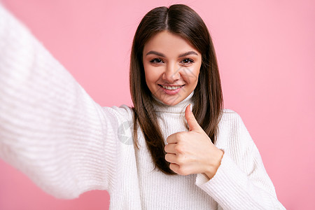 正面的青春乐观女孩在视觉上拍照 举起拇指 表示认可姿态图片