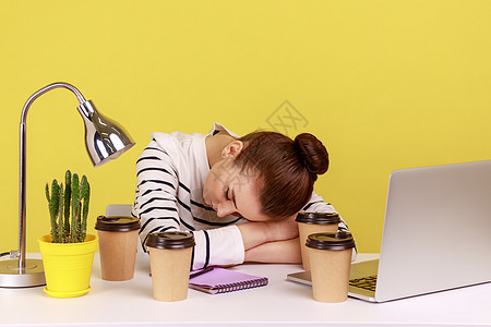 疲惫不堪的女办公室经理睡在工作场所 周围都是咖啡杯 (笑声)图片