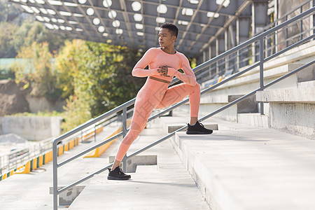 女运动员在体育场附近的粉色运动服上健身的女子运动员力量肌肉身体跑步耐力女士平衡运动动机练习图片