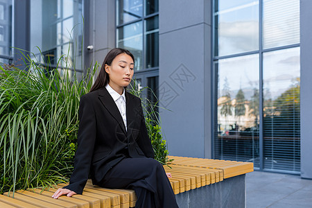 Sad Asiian 被开除的坐在长凳上坐在办公室附近压抑的妇女图片