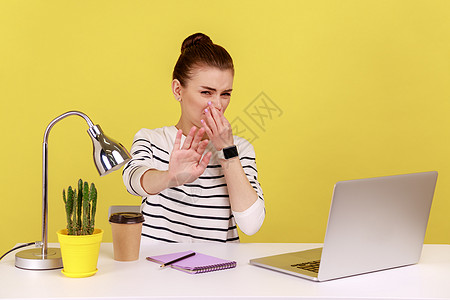 女性办公室工作人员屏住呼吸 用手指捏她的鼻子 与令人厌恶的气味混为一谈图片