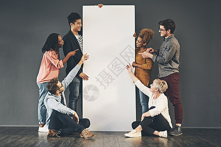 一群拿着空白白板或海报并展示广告复制空间的人 营销标语牌横幅的团队或朋友站在一起并坐在一起进行促销图片