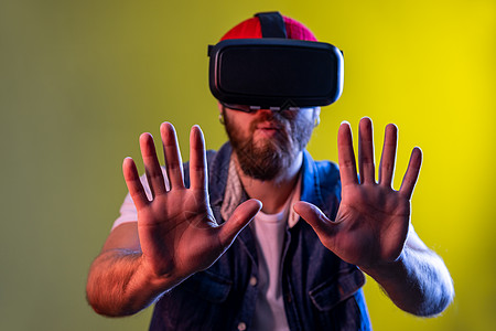 站在虚拟现实耳机上的人 试图触摸一些东西 伸展他的手臂向前图片