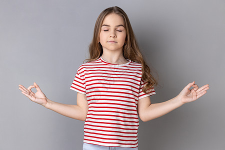 穿T恤的小女孩做瑜伽 呼吸 闭着眼睛 放学后冷静下来图片