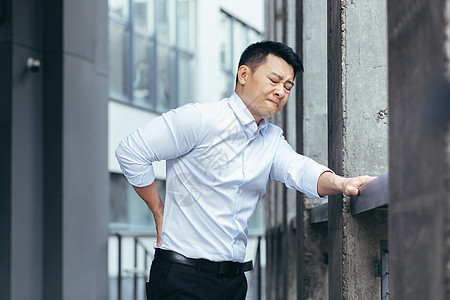 办公室附近疲劳的亚洲商务人士 做回按摩 背部疼痛 老板休息肌肉身体施工腰椎腹部痛苦男人学生药品衬衫图片