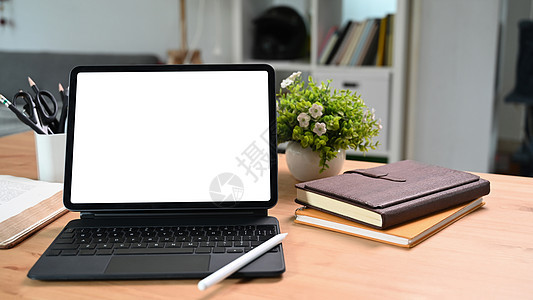 用白色显示器 书本和木制桌上的家用植物混合数字平板电脑图片