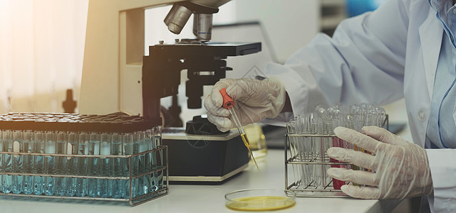 特写生物化学实验室研究 化学家正在实验室用显微镜设备和含有化学液体的科学实验玻璃器皿分析样品图片