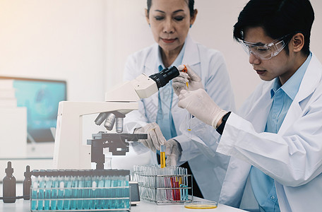 在生命科学实验室工作的医疗保健研究人员 年轻的女研究科学家和高级男主管在研究实验室准备和分析显微镜载玻片细胞学生烧杯样本实验助手图片